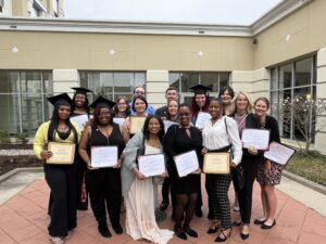 individuals standing with diplomas